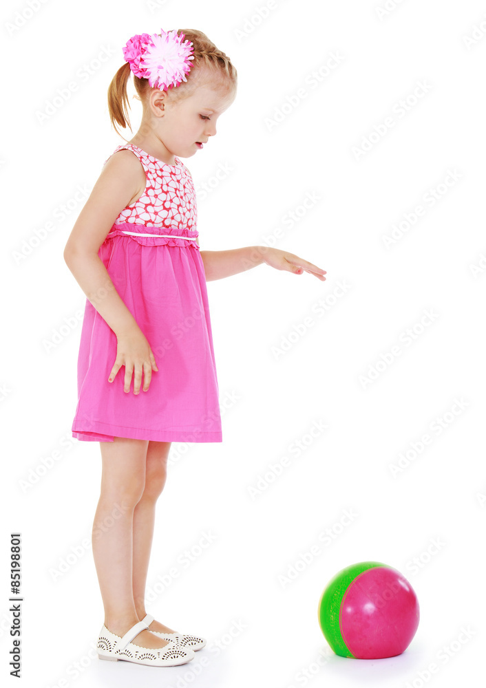Adorable blonde girl in short summer dress playing ball while st Adorable blonde girl in short summer dress playing ball while st