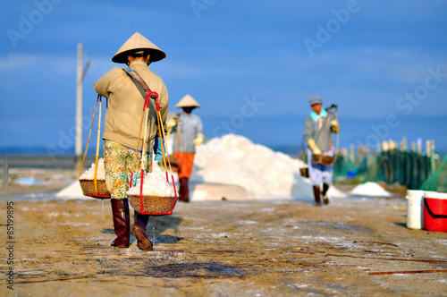 Foto Women are working very hard to collect salt from the extract fields to the stora