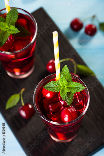 Wallpaper Mural Glass of cherry juice on blue wooden table Torontodigital.ca