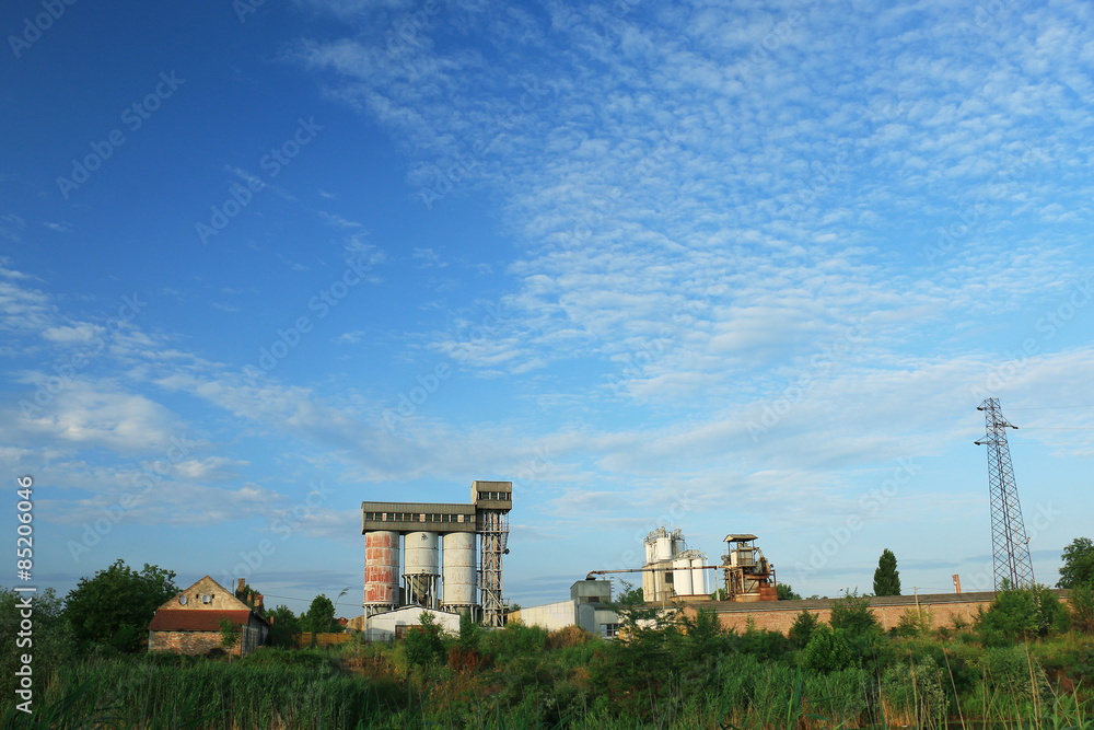 Old factory with silo tanks for corn near river Old factory with silo tanks for corn near river