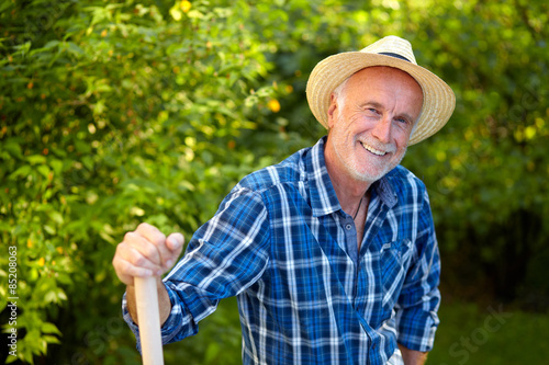 Senior man in garden with straw hat
