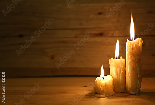  Burning old candle on wooden vintage background. 
