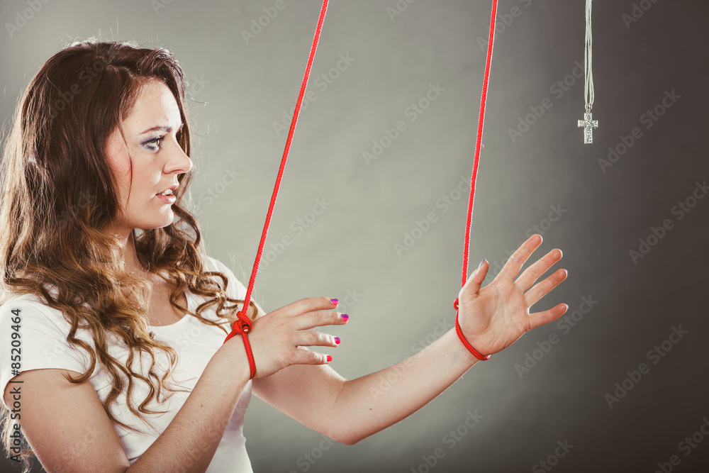 Tied woman forced to pray. Fake faith. Religion. 스톡 사진 Adobe Stock