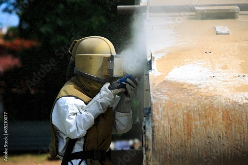 Worker is remove paint by air pressure sand blasting 