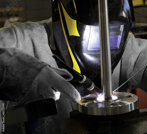 Worker welding a flanged well (Thermocouple)