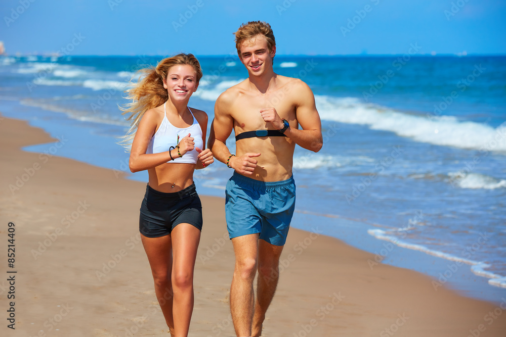 Blond young couple running on a beach in summer Blond young couple running on a beach in summer