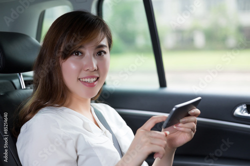 Beautiful asian young woman using mobile phone in car © zhu difeng