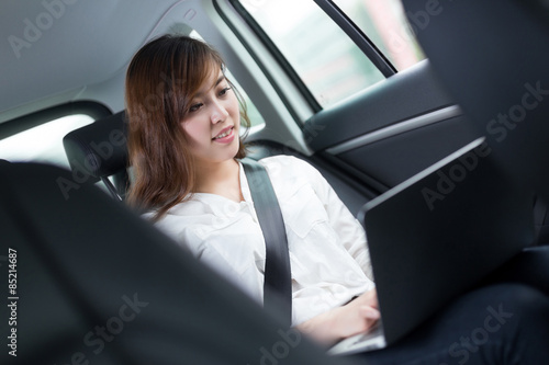 Beautiful asian young woman using laptop in car © zhu difeng