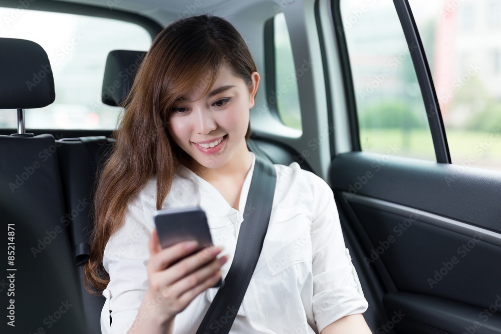 Beautiful asian young woman using mobile phone in car