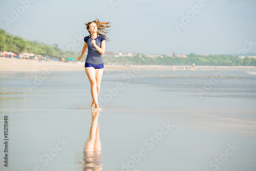 Healthy woman running on the beach, girl doing sport outdoor