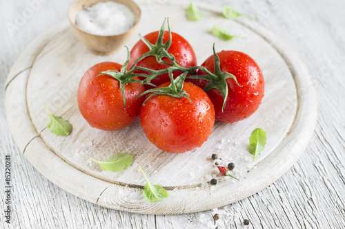 fresh tomatoes on a light wooden background