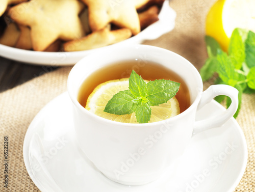 Cup of tea with slice of lemon and home made cookies. Selective focus