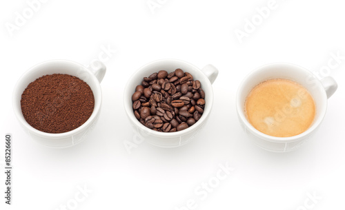 drei Tassen mit Kaffee, Kaffeebohnen und Kaffeepulver