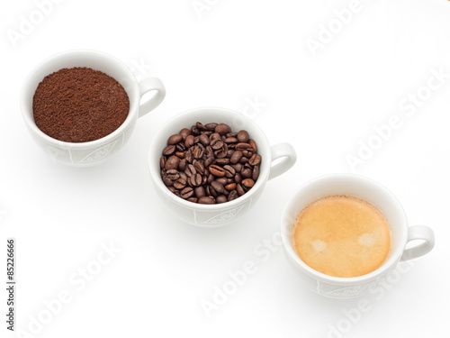 drei Tassen mit Kaffee, Kaffeebohnen und Kaffeepulver
