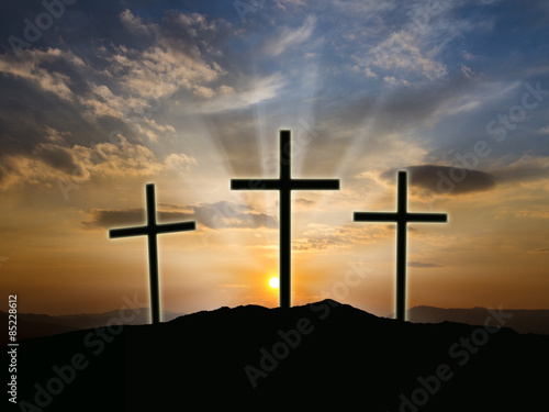 Silhouette of crosses at  sunrise or sunset with light rays.