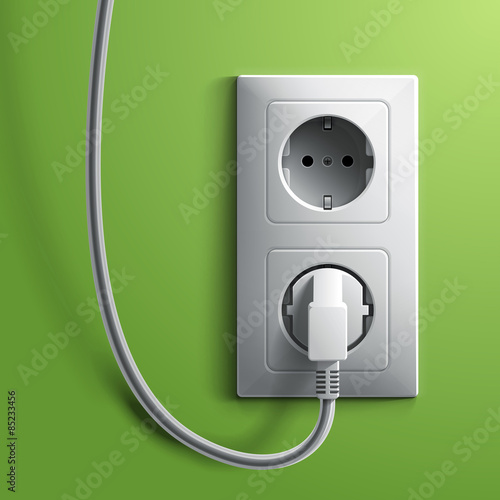 Electric white plug and socket on green wall background