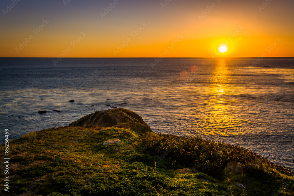 Sunset over a grassy hill and the Pacific Ocean, seen from the B