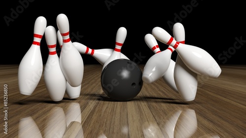 Bowling ball and pins in motion on wooden floor