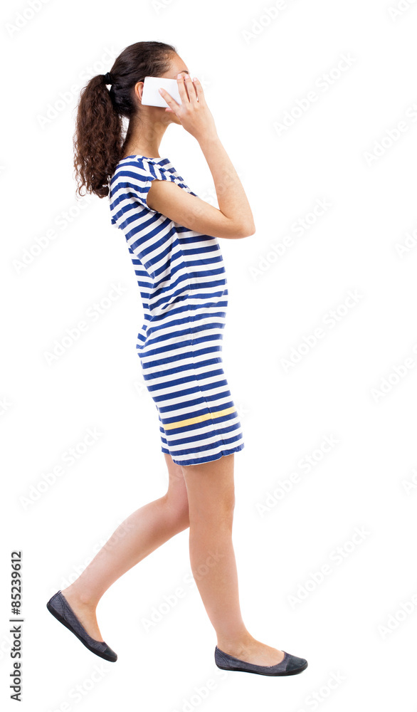 a side view of a woman walking with a mobile phone a side view of a woman walking with a mobile phone