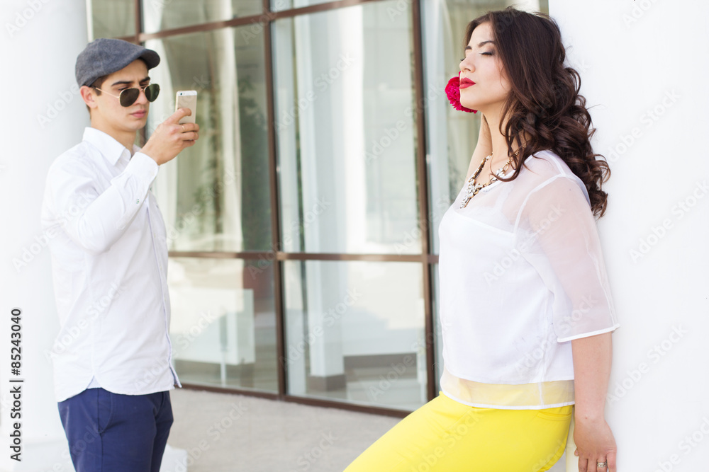 Obraz premium Boy taking photo of his beautiful girlfriend on phone camera