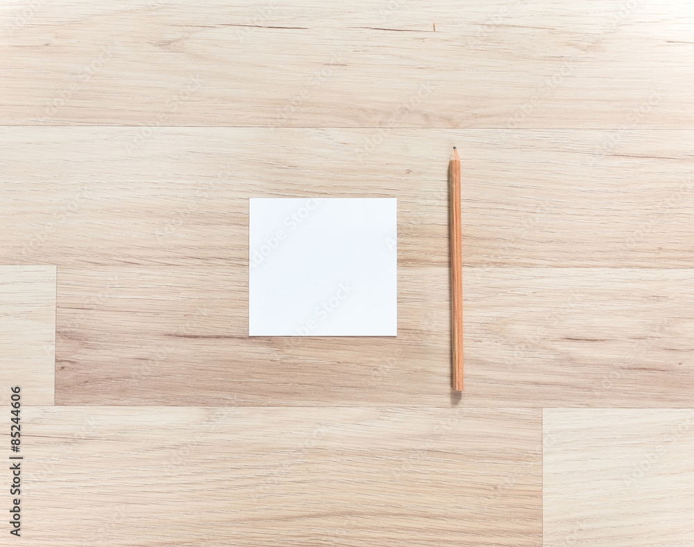 Blank paper and pencil on the wooden table. View from above Blank paper and pencil on the wooden table. View from above