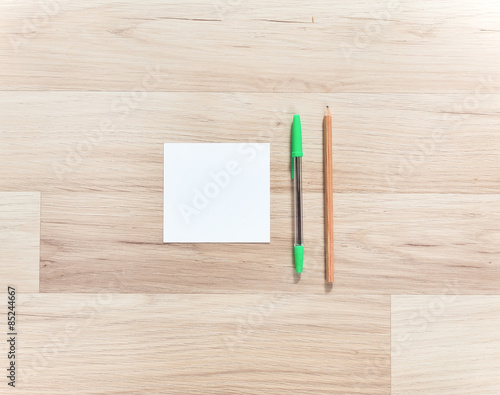 Blank paper, pen and pencils on the wooden table. View from above