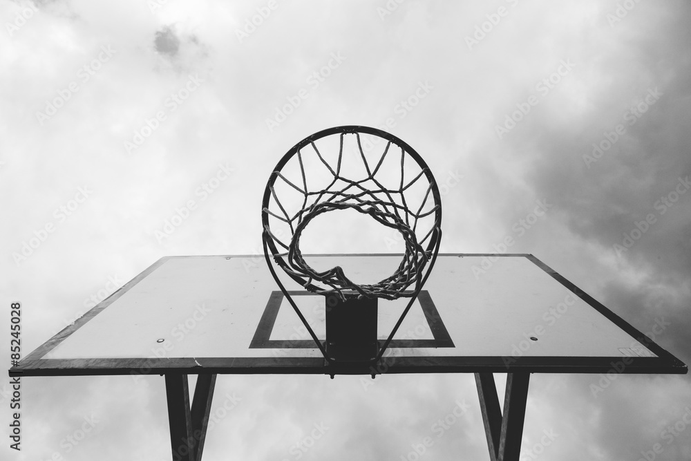 Fototapeta premium bottom view of the basketball hoop, with sky background, black and white