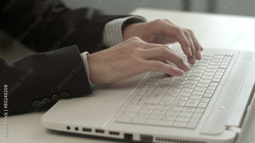 Man's hands typing on keyboard notebook Man's hands typing on keyboard notebook