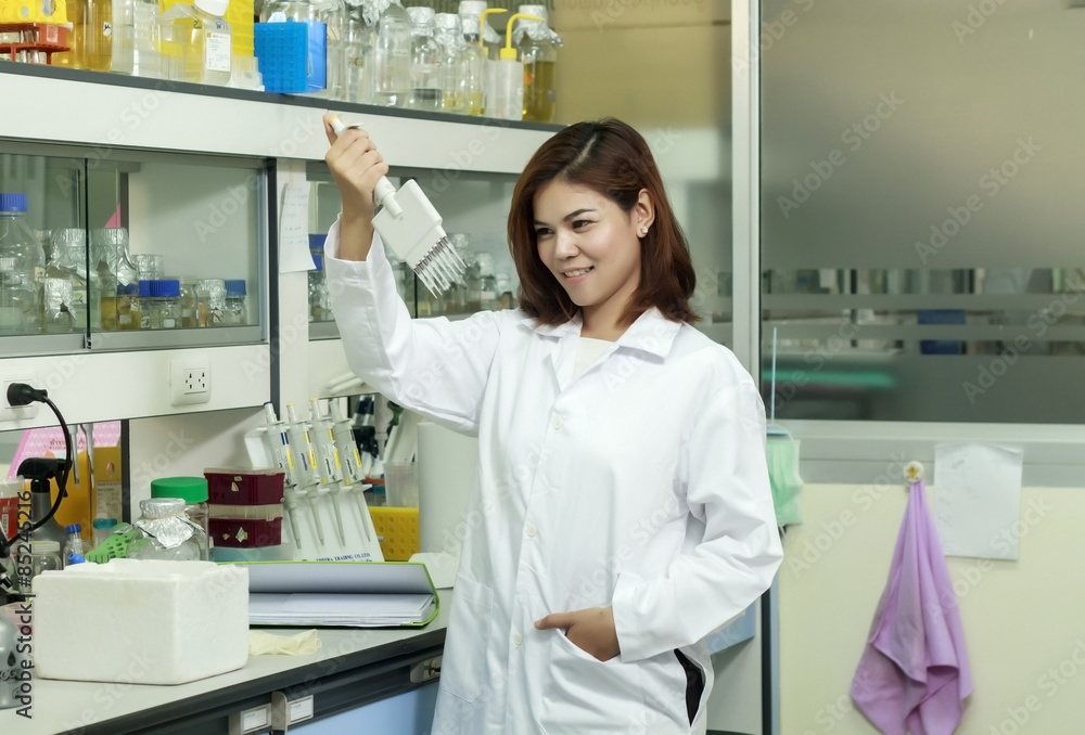 Young female tech or women asia scientist working with multichannel pipette in biological laboratory Young female tech or women asia scientist working with multichannel pipette in biological laboratory