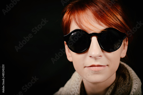 unusual woman studio with red hair and sunglasses