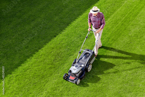 Tableau sur toile Mowing senior man in the garden