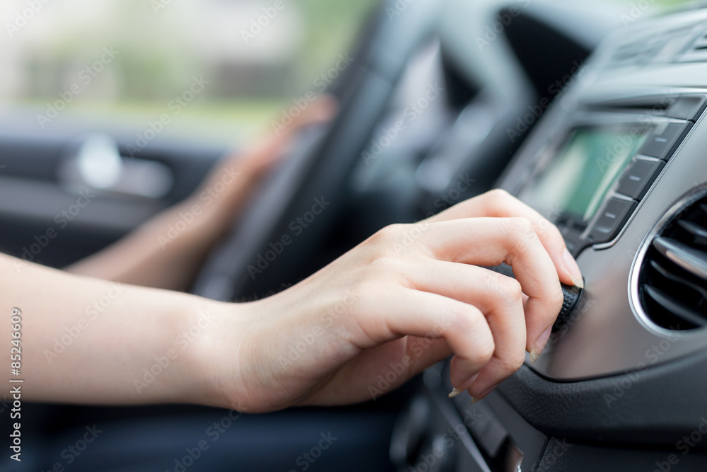 asian femle driver touching dashboard in car