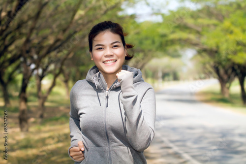 Running woman. Female runner jogging during outdoor on road .Young mixed race girl jogging in fall colors.