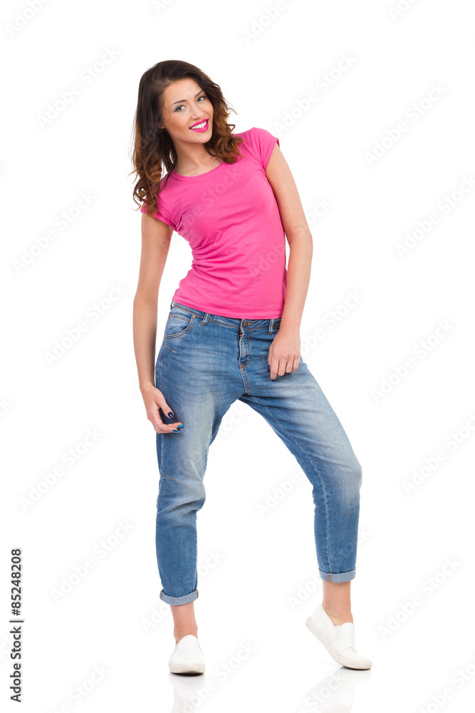 Woman In Saggy Pants. Cheerful young woman in pink shirt and jeans posing. Full length studio shot isolated on white. Woman In Saggy Pants. Cheerful young woman in pink shirt and jeans posing. Full length studio shot isolated on white.