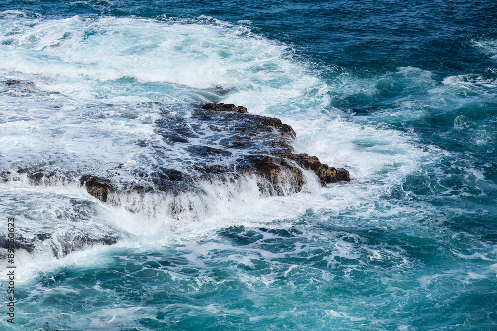 Raging sea flows over lave rocks on shore line Raging sea flows over lave rocks on shore line