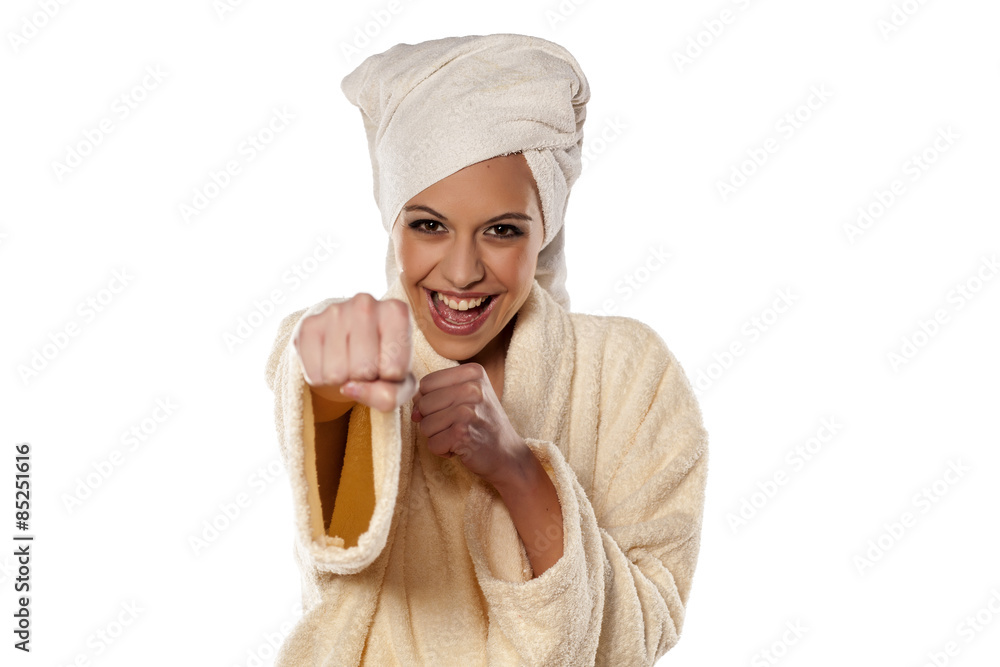 smiling woman in bathrobe and towel on her head showing his fist smiling woman in bathrobe and towel on her head showing his fist