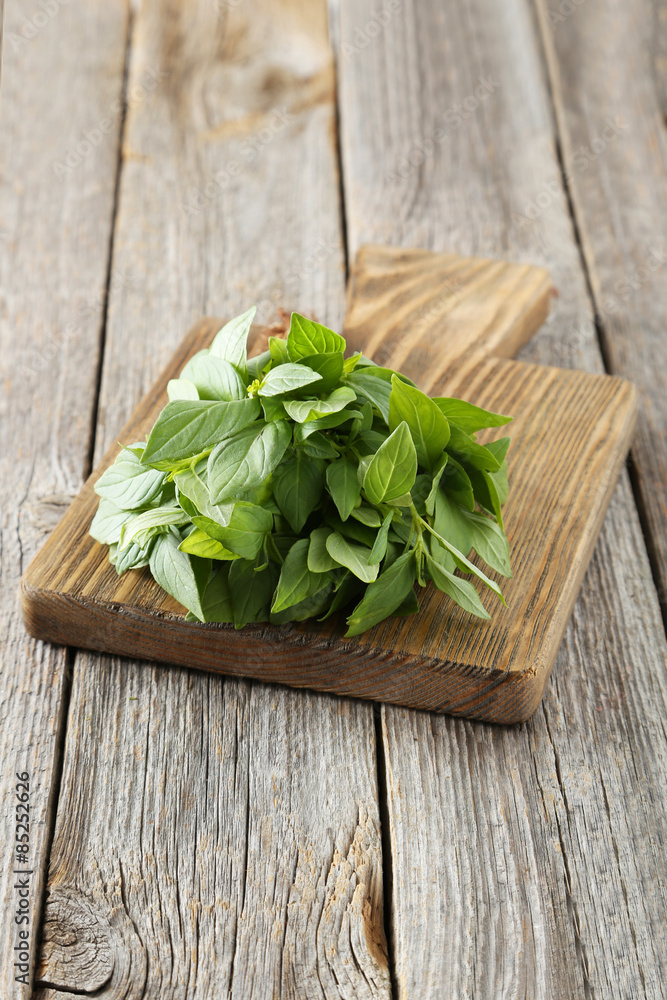 Basil leaves on cutting board grey wooden background Basil leaves on cutting board grey wooden background