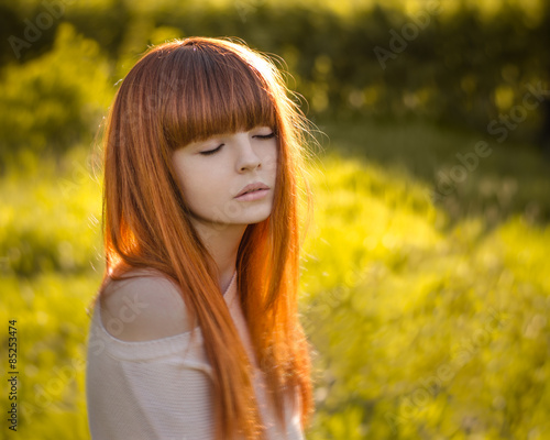girl with red hair, Red-haired girl standing in the woods and the sun shines