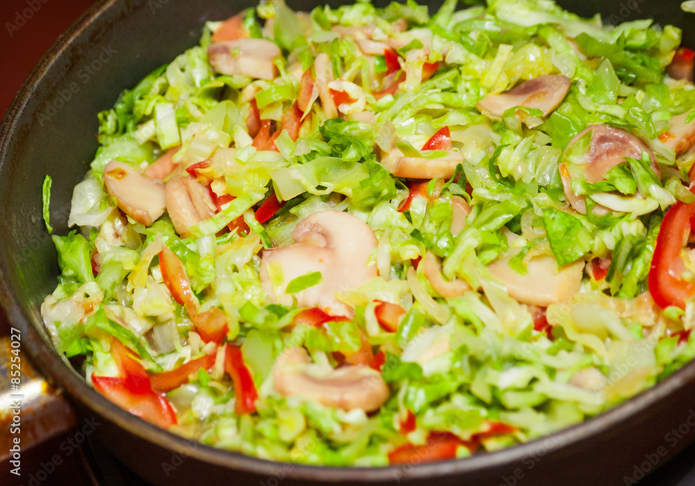 Cooking cabbage with mushrooms in fried pan Cooking cabbage with mushrooms in fried pan