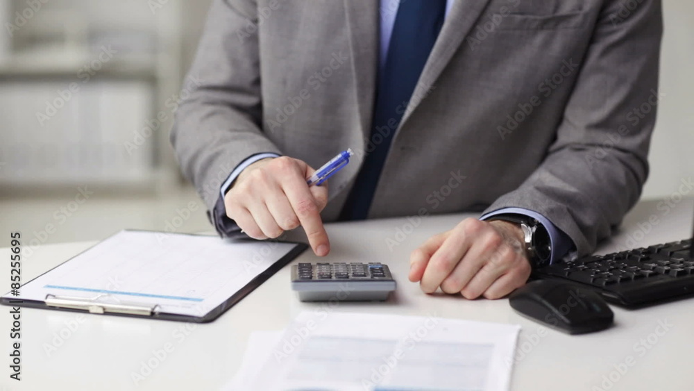 close up of businessman with papers and calculator close up of businessman with papers and calculator