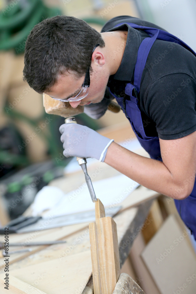 Young apprentice in carpentry working piece of wood