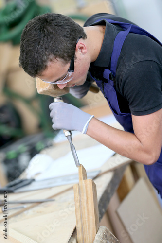 Young apprentice in carpentry working piece of wood