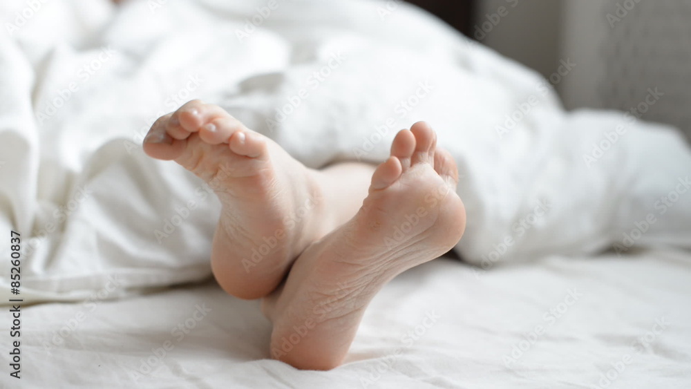 Pair of child's feet under the blanket. Pair of child's feet under the blanket.
