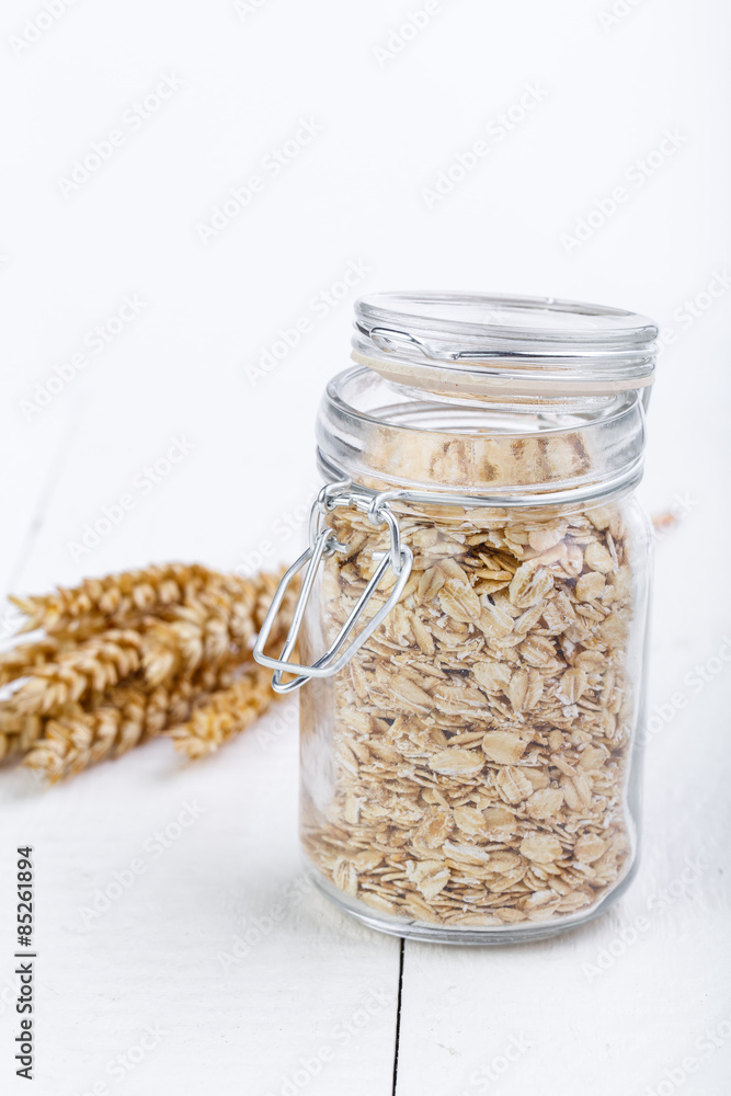 The oat flakes in glass jar and wheat. The oat flakes in glass jar and wheat.