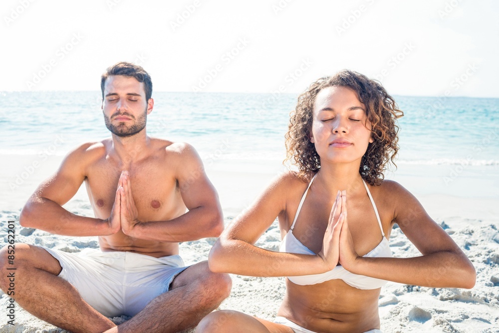 Happy couple doing yoga beside the water Happy couple doing yoga beside the water
