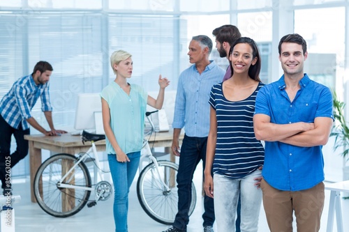 Happy business friends standing with arms crossed