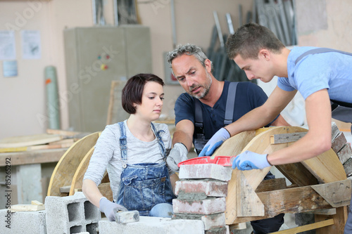 Foto Instructor teaching teenagers brick laying