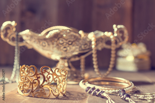 Obraz na płótnie Vintage golden bracelet and silver vase with jewelry on wooden background