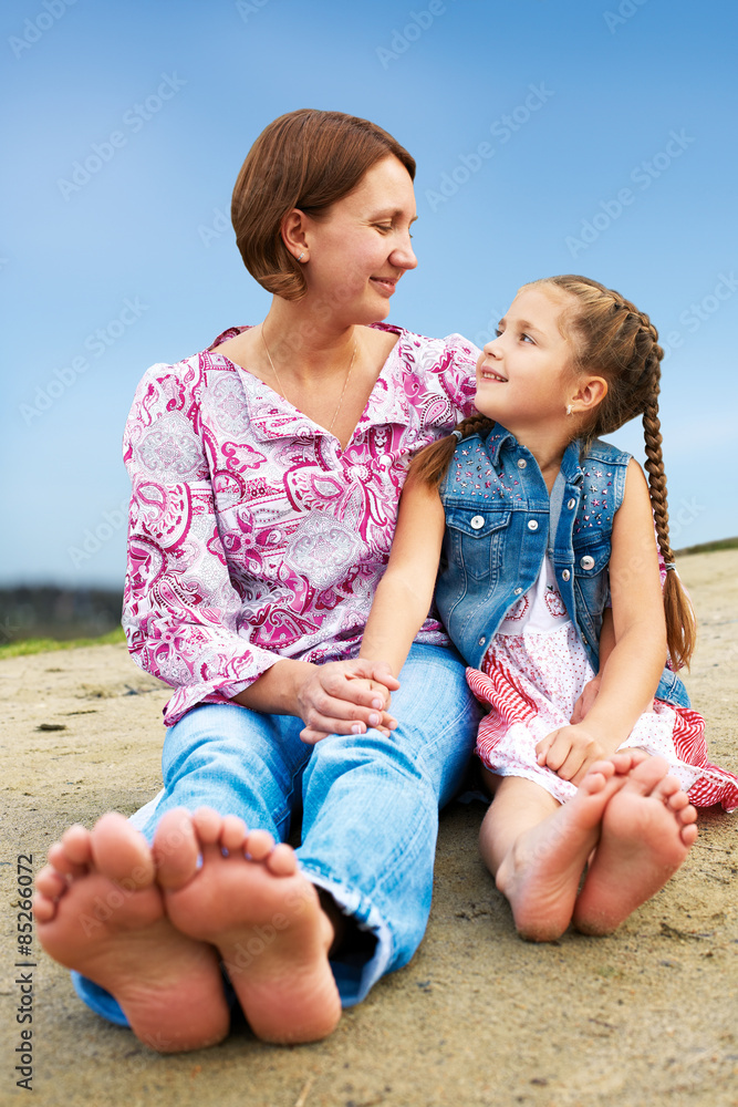 Happy american mother and daughter laughing together outdoors