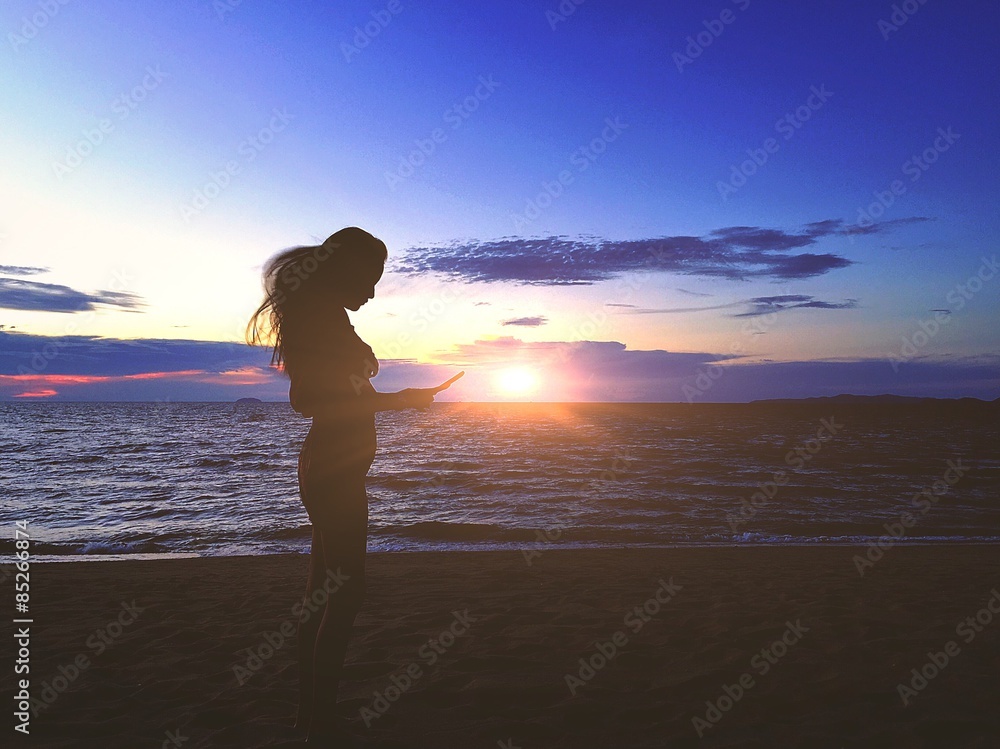 girl playing smartphone on beach
